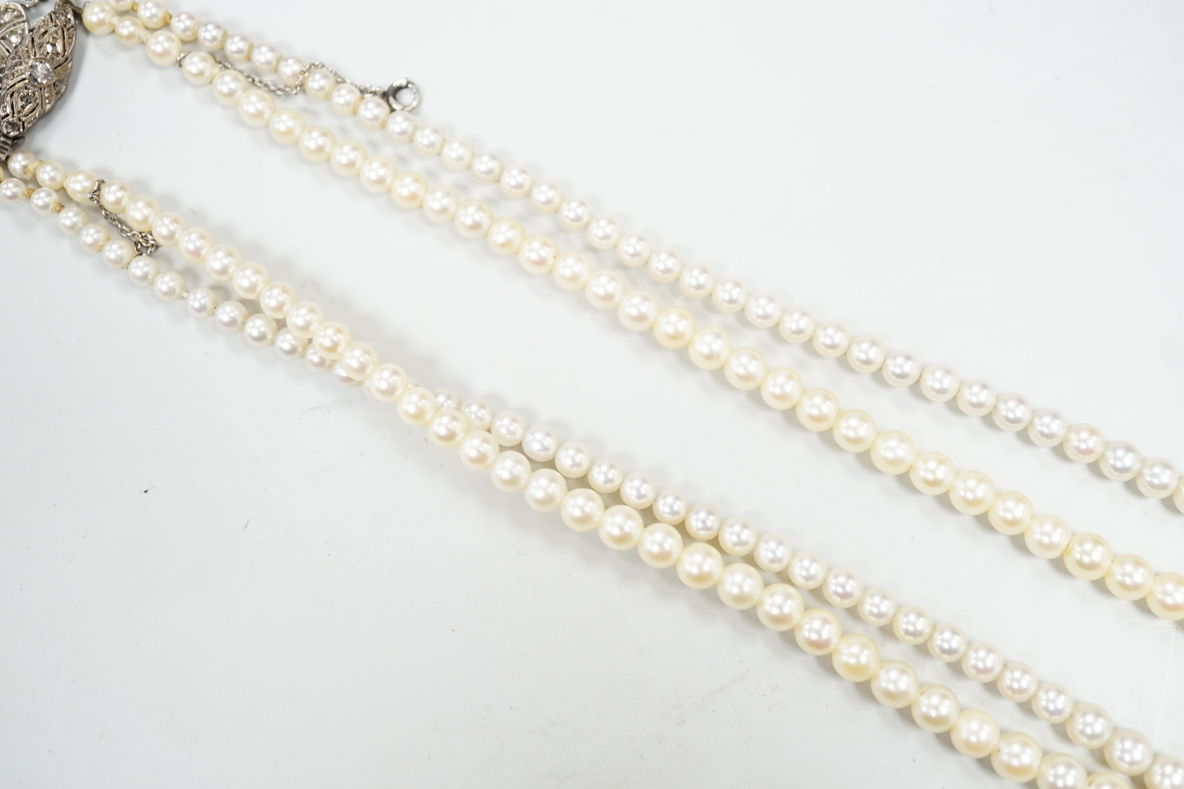 Two single strand graduated cultured pearl necklaces, both with diamond set white or yellow metal clasps, 39cm and 44cm.